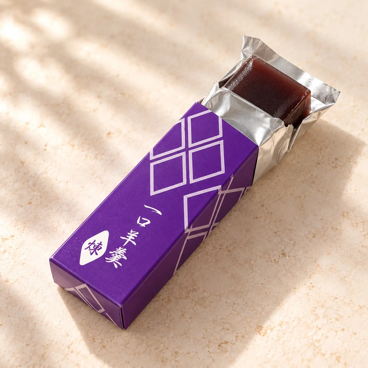 Sweet bean yōkan partly unwrapped in its purple Japanese carton